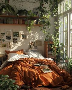 an unmade bed with orange sheets and plants on the shelves in front of it