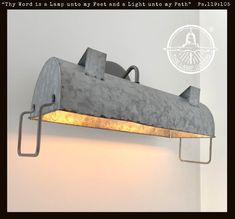 a light that is hanging from the side of a wall with a metal beam on it