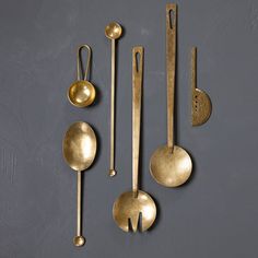 brass spoons and measuring spoons are arranged on a gray surface