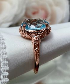 Simulated Aquamarine or Natural Sky Blue Topaz Gold plated Ring Edward Design#70z (smaller version) Custom Made This Edwardian reproduction ring is rose gold plated sterling silver. The delicate filigree is centered with a stunning Sky Blue gemstone solitaire, choose between a simulated or natural stone. This full cut oval gemstone is 12mm in length and 10mm in width. This ring also sits 7mm off the finger. The inside of the band is marked 925 for sterling silver. There is a beautiful floral des Oval Aquamarine Jewelry For Wedding, Oval Aquamarine Wedding Jewelry, Rose Gold Aquamarine Gemstone Jewelry, Oval Rose Gold Topaz Ring For Anniversary, Oval Blue Topaz Rose Gold Ring, Oval Rose Gold Blue Topaz Ring, Rose Gold Blue Topaz Jewelry With Accent Stones, Oval Light Blue Jewelry With Accent Stones, Oval Rose Gold Ring With Blue Topaz