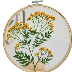 a close up of a embroidery on a white surface with yellow flowers in the center