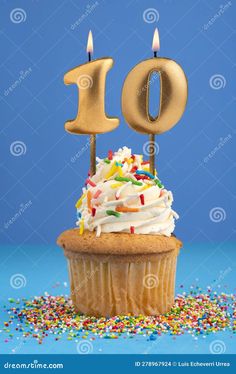 a cupcake with candles in the shape of an number 10 on it and sprinkles