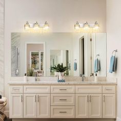 a large bathroom with two sinks and mirrors