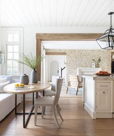 a kitchen and living room with white walls, wood flooring and exposed beams in the ceiling