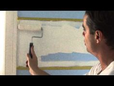 a man using a paint roller to paint a wall