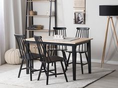 a table and chairs in a room with a rug on the floor next to it