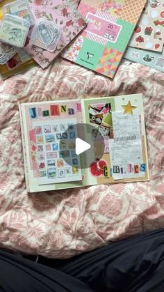 an open book sitting on top of a bed covered in pink and white paper sheets