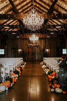 an indoor wedding venue with chandelier and chairs set up for the guests to sit down