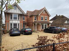 several cars parked in front of a large house