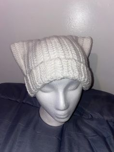 a white knitted hat sitting on top of a mannequin's head