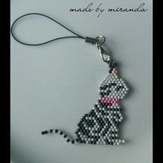 a beaded key chain with a black and white cat on it's side