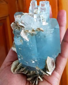 a person holding some kind of rock with ice crystals in it's palm hand