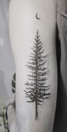 a black and white photo of a pine tree tattoo on the left upper half of the arm