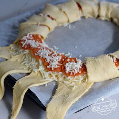 pizza dough with sauce and cheese on it in the shape of a spiral, uncooked crescent