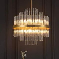 a chandelier hanging over a table with vases and flowers on it's side