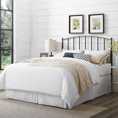 a bed with white sheets and pillows in a room