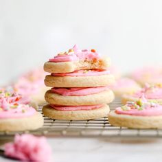 pink frosted cookies with sprinkles on a cooling rack, ready to be eaten