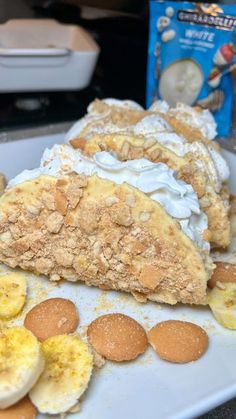 a white plate topped with banana slices and cream cheesecake next to a box of cereal