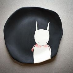 a black plate with a white rabbit on it