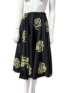 Black circle skirt featuring a yellow rose floral print. Midi length. Has a cotton twill waist band and side zipper. Vintage from the 1950s. Great vintage condiition, no major flaws to note, a couple very small threadbare spots near the waist but very minor. No tags. Fits best XS/S  Waist -12.75" Length -27.75" Hips - free