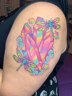 a woman's arm with a colorful tattoo design on the back of her shoulder