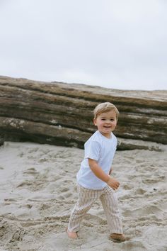 a little boy that is standing in the sand