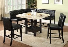 a kitchen table with black chairs and a white marble topped dining room table in front of a window