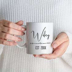 a woman holding a white coffee mug with the name wife on it in her hands