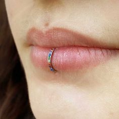 a woman's nose with a ring on top of her lip and the end of her tongue