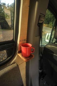 a red cup sitting on top of a wooden shelf in the back of a truck