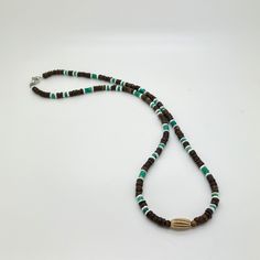 This handcrafted tribal necklace features brown coconut heishi beads, REAL green Turquoise, white Shell and Carved horn focal center bead with choice of silver or 18K Gold-plated stainless steel clasp. Note: focal center bead is randomly selected from bone, horn or sandcast clay; therefore, no two will be identical. Turquoise is the stone of truth, grounding, protection, and calmness. It enhances communication, amplifies intuition, and brings insight and wisdom. Turquoise effectively dispels neg Handmade Brown Heishi Beads, Artisan Necklace With Spacer Beads For Beach, Beach Necklace With Brown Round Beads, Brown Polished Beads For Beach, Earthy Round Beads Necklace For The Beach, Brown Heishi Beads Round Necklaces, Artisan Brown Beaded Necklace For Beach, Bohemian Brown Shell Necklace With Round Beads, Brown Heishi Beads Necklace For Gift