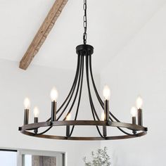 a chandelier hanging from the ceiling in a room with white walls and wooden beams