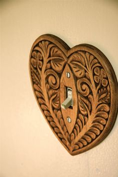 a wooden heart shaped light switch cover on a wall in the shape of a heart