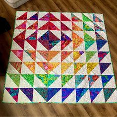 a multicolored quilt is laying on the floor