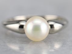 This gorgeous vintage piece is crafted of sleek white gold that features a perfect polish. Utterly simple, this vintage piece features a single, modestly sized pearl framed by rounded tapered shoulders. Metal: 14K White Gold Gem: Pearl Gem Measurements: 7 mm, Round Ring Size: 4.50 Marks: "14K" Stamped on the inside band Formal Polished Pearl Ring With Round Cut, Formal Round Cut Polished Pearl Ring, Classic Round Pearl Ring With Pearl Drop, Classic Pearl Ring With Pearl Drop, Timeless Pearl Ring With Polished Finish For Formal Occasions, Classic Pearl Drop Ring, Formal Minimalist Pearl Ring With Polished Finish, Minimalist Polished Pearl Ring For Formal Occasions, Classic White Pearl Ring With Polished Finish