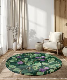 a green rug with purple flowers is in the middle of a room next to a chair