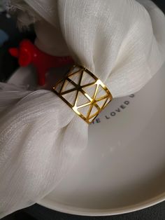 a white plate topped with a gold napkin ring