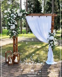 an outdoor ceremony setup with white flowers and greenery