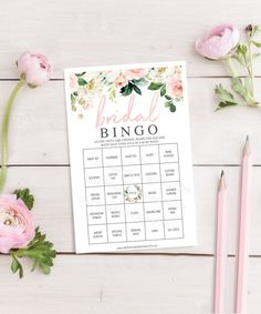 the baby shower game is next to pink flowers and pencils on a white table