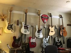 guitars are lined up on the wall in an office