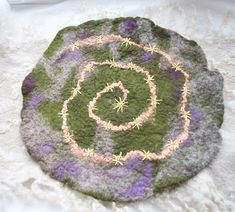 a green and purple rug sitting on top of a white surface