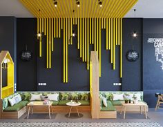 the interior of a restaurant with yellow and black decorations on the walls, tables and benches