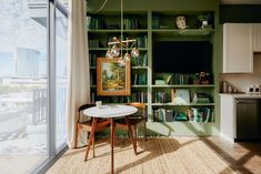 a table and chairs in front of a bookshelf