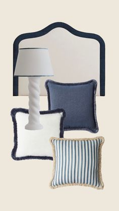 three pillows and a lamp on a white wall next to a bed with a blue headboard