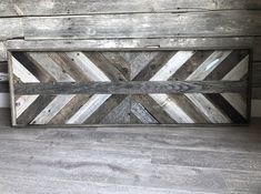 a wooden sign sitting on top of a hard wood floor next to a white wall