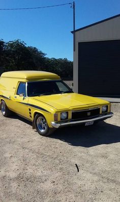 a yellow station wagon parked in front of a garage