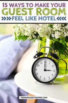 an alarm clock sitting on top of a table next to a vase filled with flowers