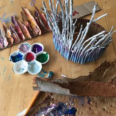 several different types of paint sitting on top of a wooden table next to other paints