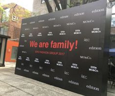 a large black sign that says we are family on the side of a building in an urban area