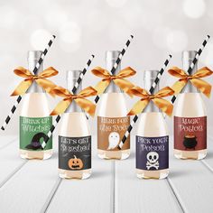 six bottles with halloween labels on them and ribbons tied around the top, sitting on a white table